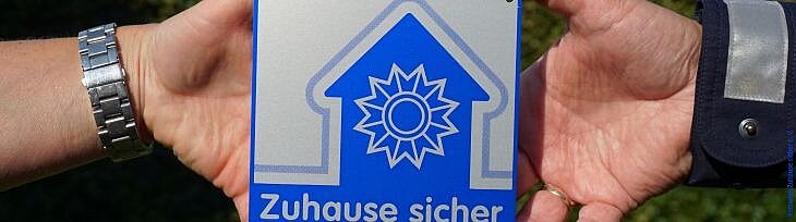 Zwei Hände mit Präventionsplakette