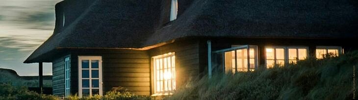 Beleuchtetes Haus in den Dünen