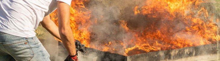 Mann löscht Feuer mit Feuerlöscher