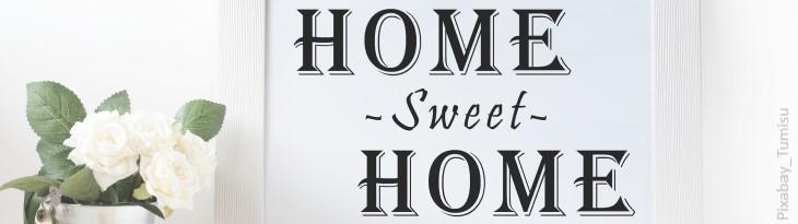 Schild Home-Sweet-Home neben weißer Blume