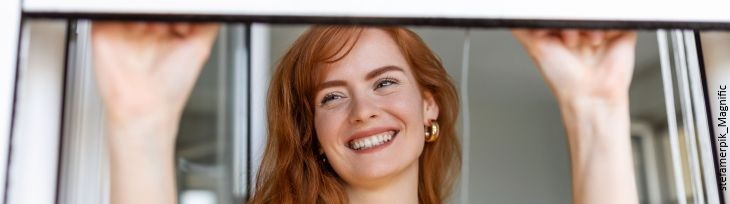 Frau am offenen Fenster